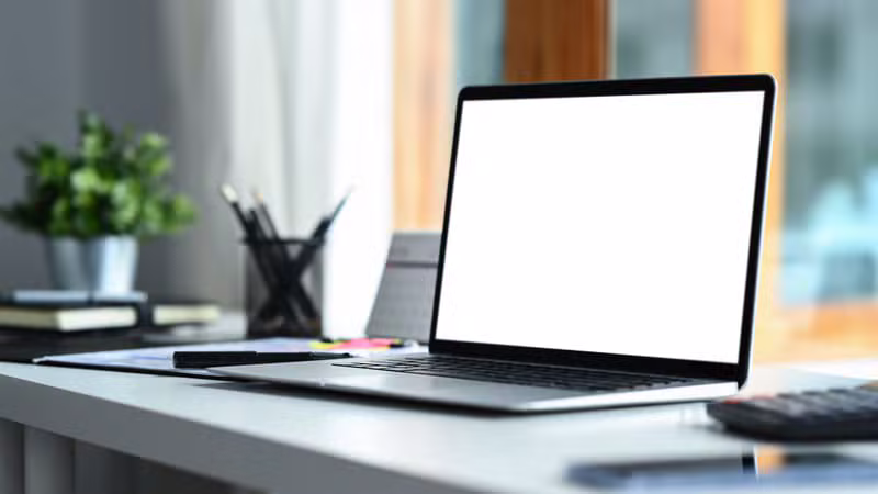 Laptop displaying a professionally designed book launch lead magnet with coffee and notebooks