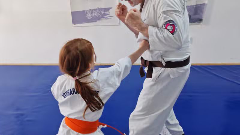 Martial arts instructor training a child