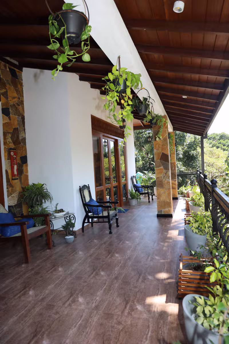 Plant-filled verandah at Mahaweli Haven with wooden ceiling and garden views
