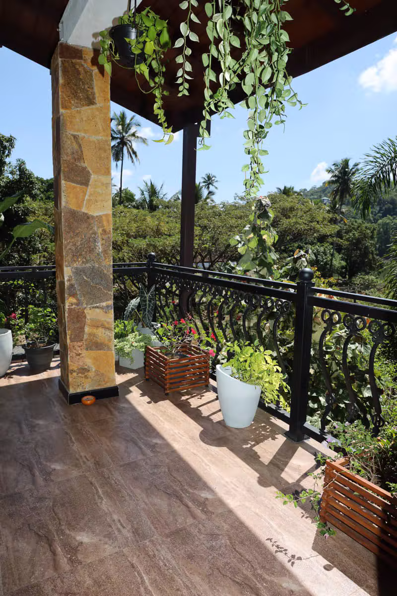 Balcony plants and hillside greenery at Mahaweli Haven