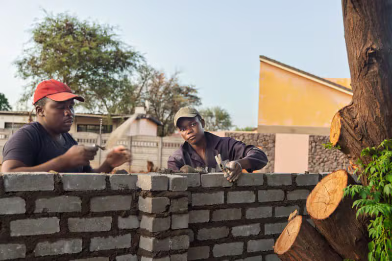 Black African workers developing an eco-friendly brick house project
