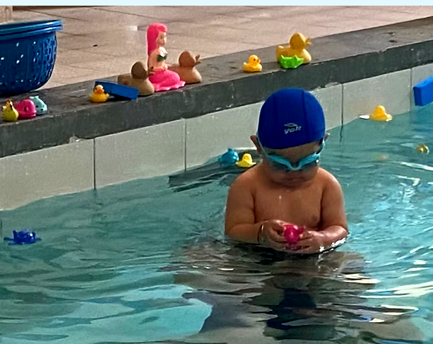 Instructor de natación enseñando en la piscina