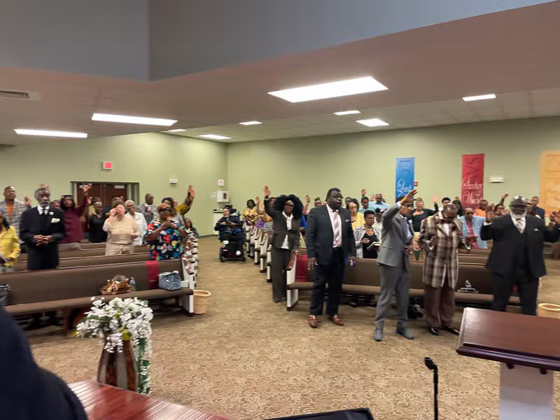 Church family standing together in prayer