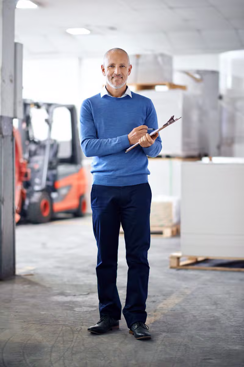 Logistics manager reviewing shipping documents in a warehouse