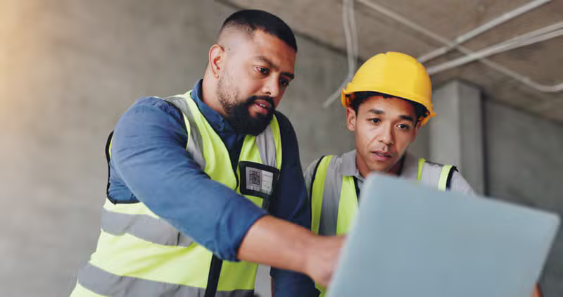 Engineers reviewing blueprints at a construction site