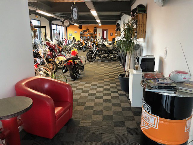 Mécanicien inspectant une moto custom dans notre atelier