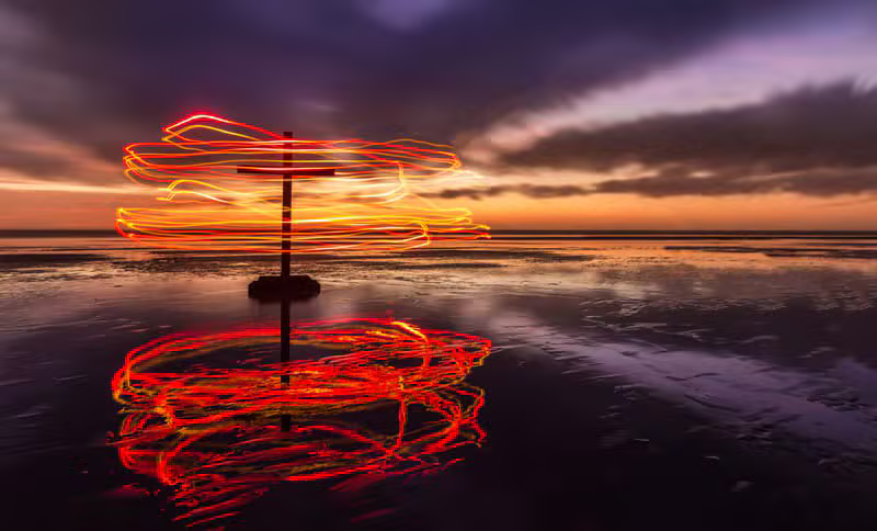 Glowing Christian cross against a warm sunset