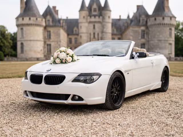 BMW blanche cabriolet F&F PRESTIGE décorée pour un mariage, garée devant le Château de Vic-sur-Aisne. 