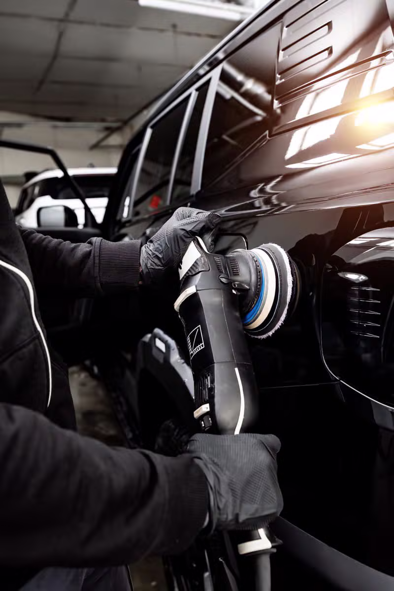 Expert réalisant un polissage de carrosserie sur un véhicule de luxe