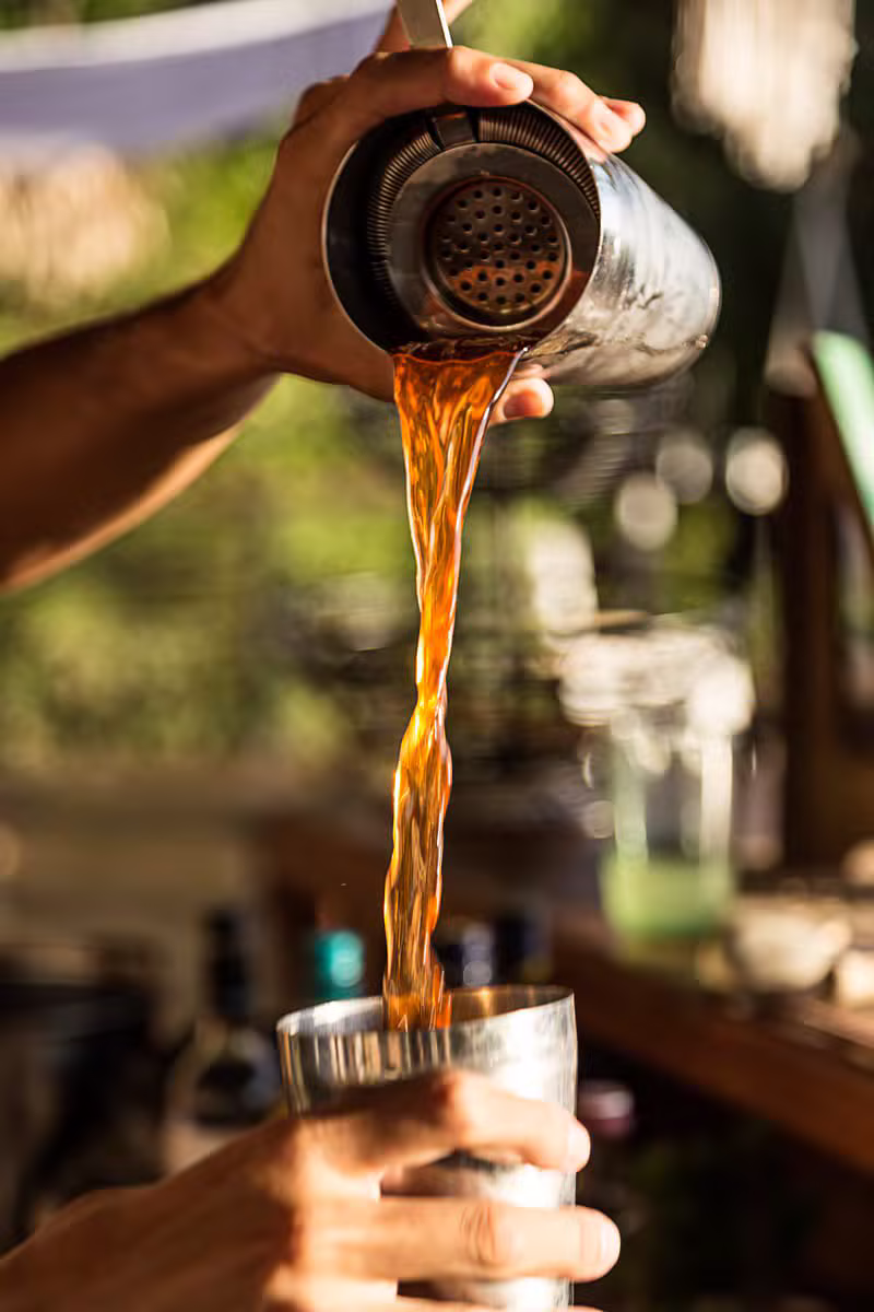 Bartender pouring a craft cocktail at a mobile bar