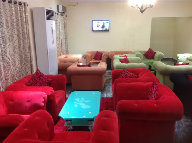 OSPUC HOTEL guest lounge with red and green seating