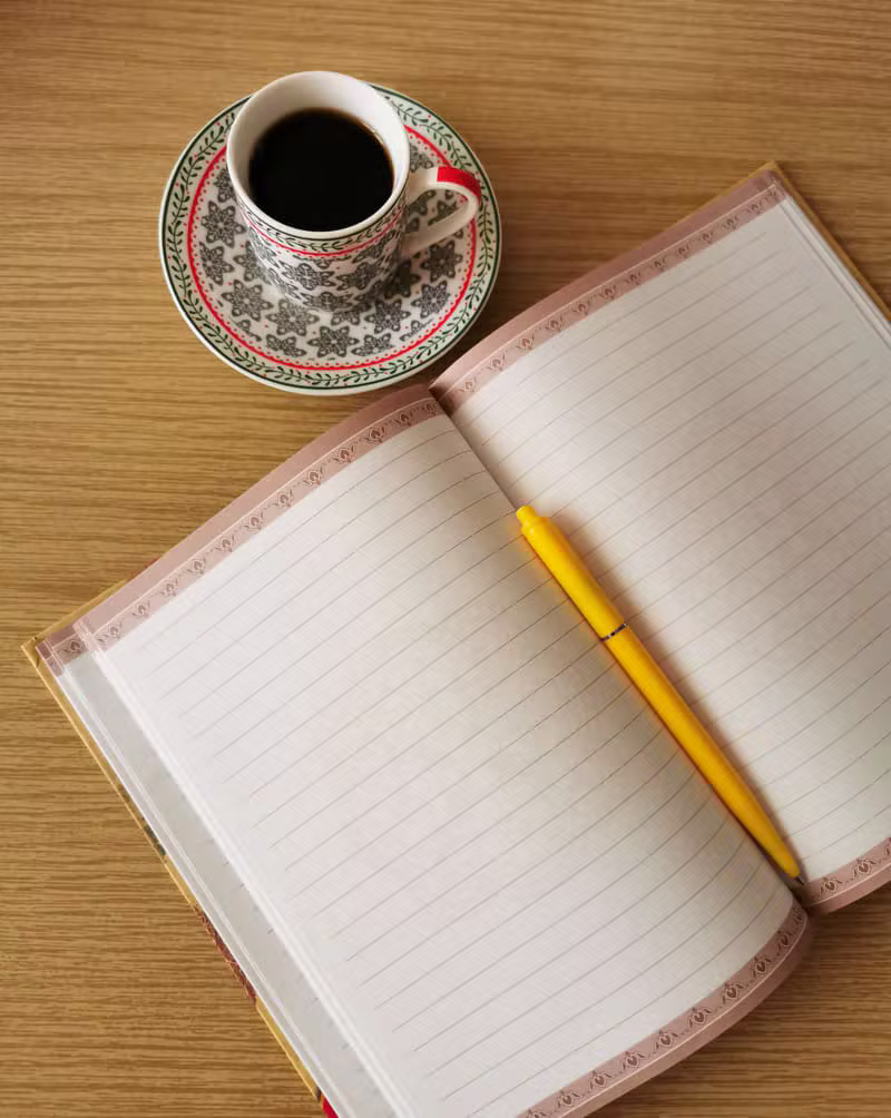Journal beside a book and coffee
