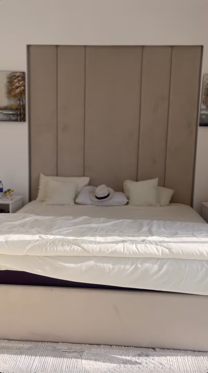 Bedroom with upholstered headboard inside Turjman Oasis Villa