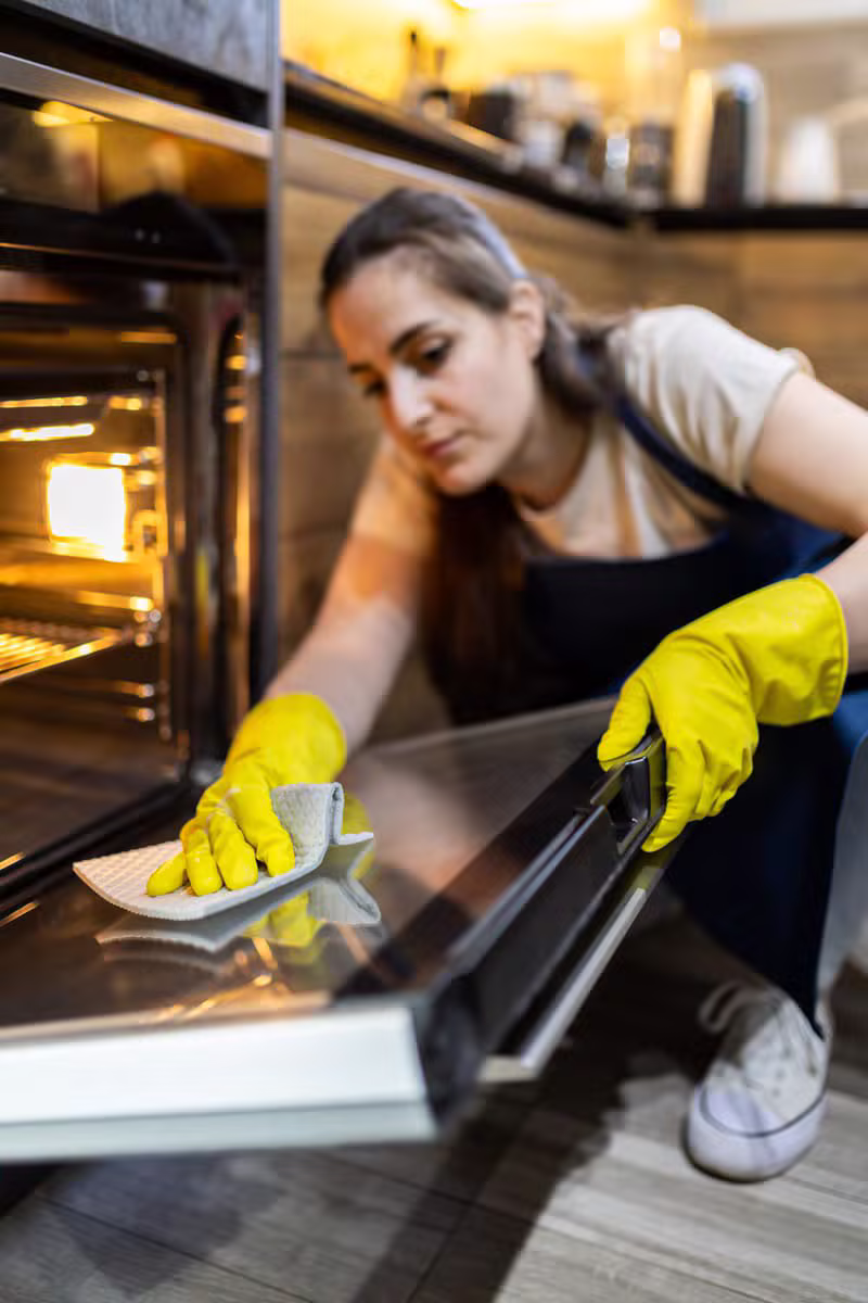Professional cleaner preparing a bright kitchen