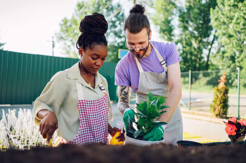 A support worker assisting a participant in a community garden