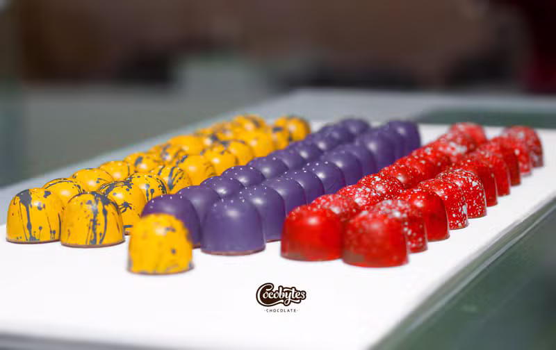 Hand-painted yellow, purple, and red chocolate bonbons