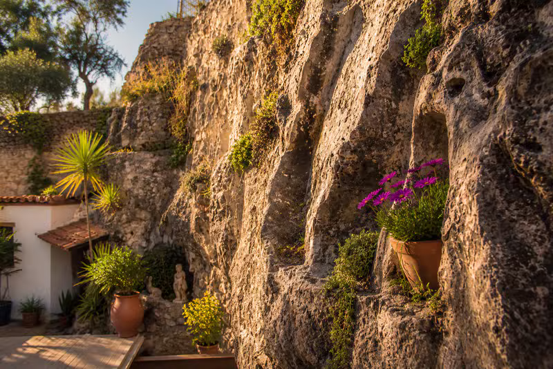 Muro de piedra con macetas al sol