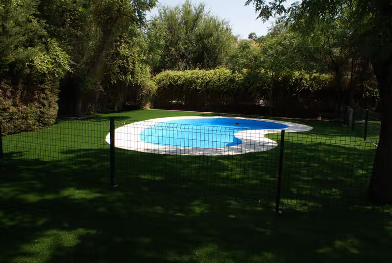 Piscina municipal de Sorihuela rodeada de jardines y árboles