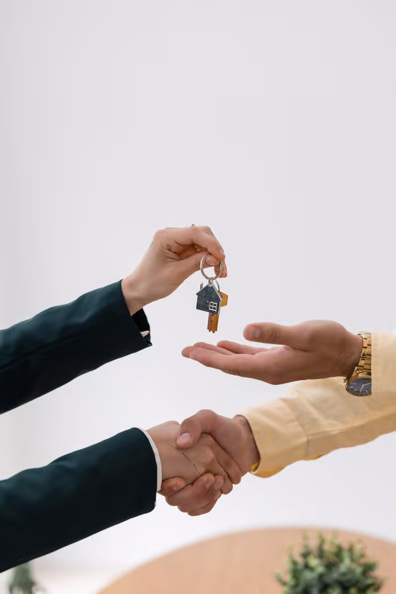 Real estate agent shaking hands with clients