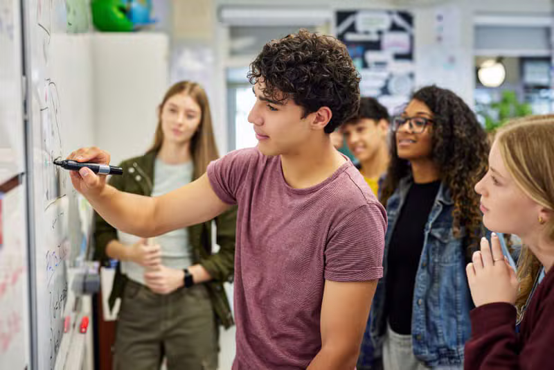 Adultes d'origines diverses étudiant ensemble dans une salle de classe