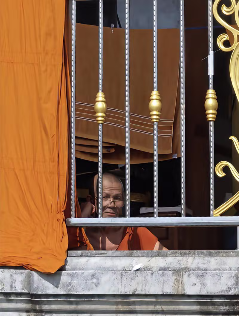Moine bouddhiste à la fenêtre d'un temple