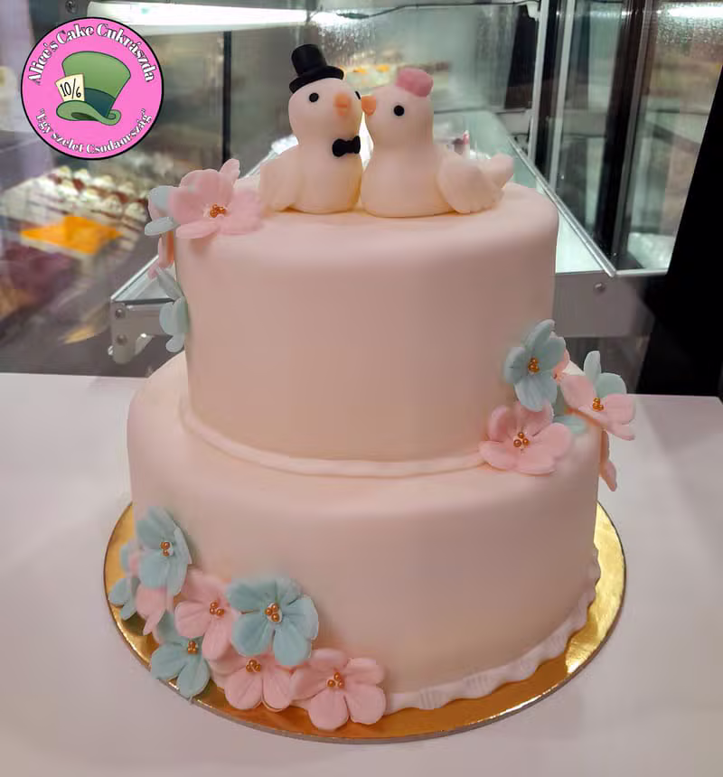 Rózsaszín esküvői torta galamb díszítéssel