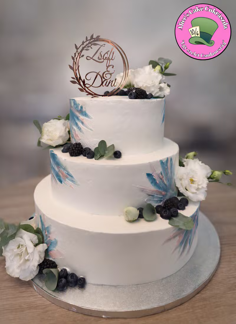 Háromszintes fehér torta bogyós és levéldíszítéssel