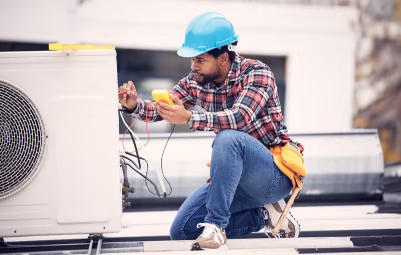 Professional handyman repairing air conditioning