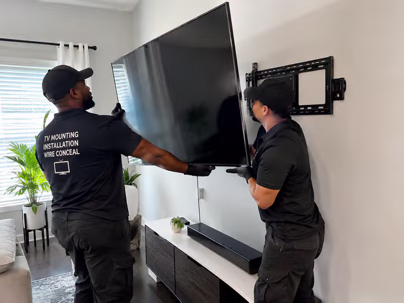 Handyman professionally installing a TV on a wall
