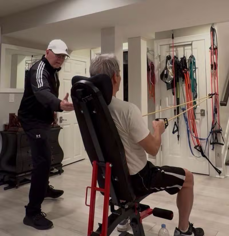 Coach instructing client in home gym on proper form and muscle contraction