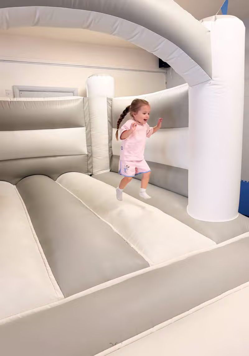 A toddler mid-bounce on the bouncy castle