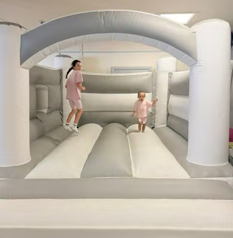Two children jumping on the large bouncy castle
