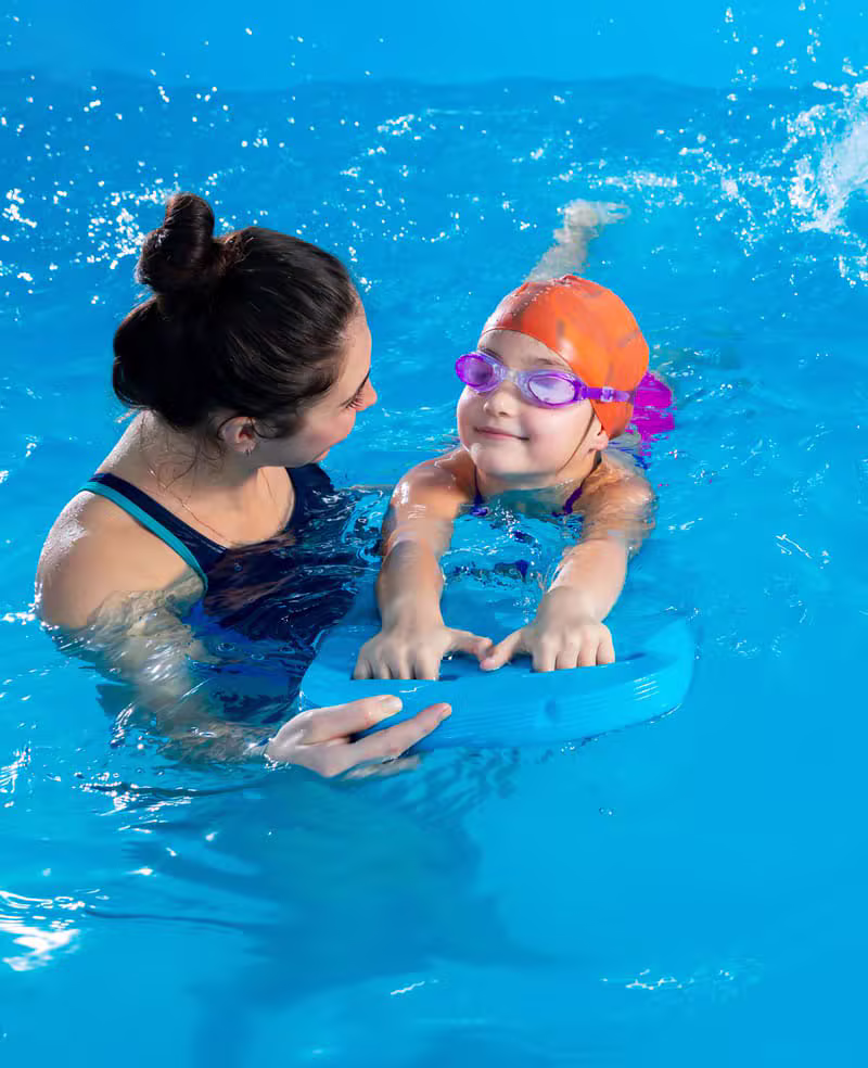 Moniteur de natation apprenant à nager à un enfant