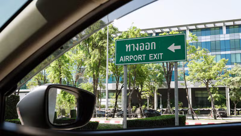 Professional airport transfer driver waiting at an arrival terminal