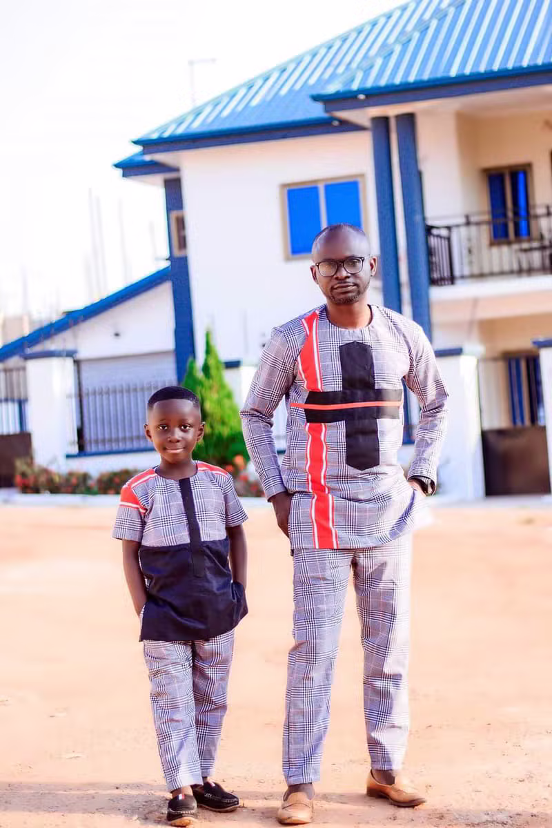 Father and son wearing matching grey checked African print outfits