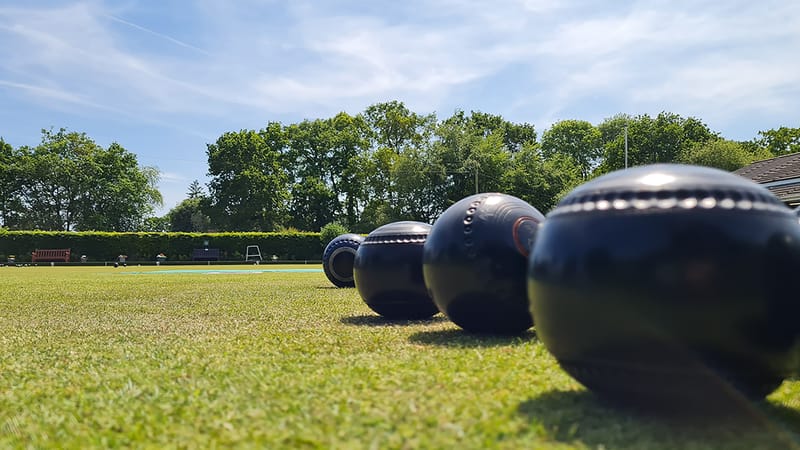 People enjoying a game of lawn bowls on a sunny green