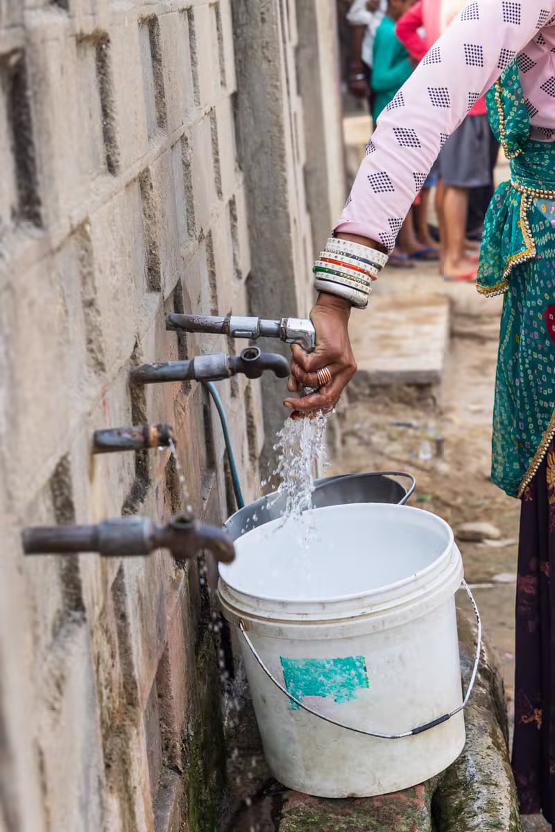 Community members collecting water at a shared tap stand