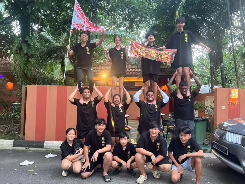 Hong Quan troupe cheering together on the lorry with flags and banners