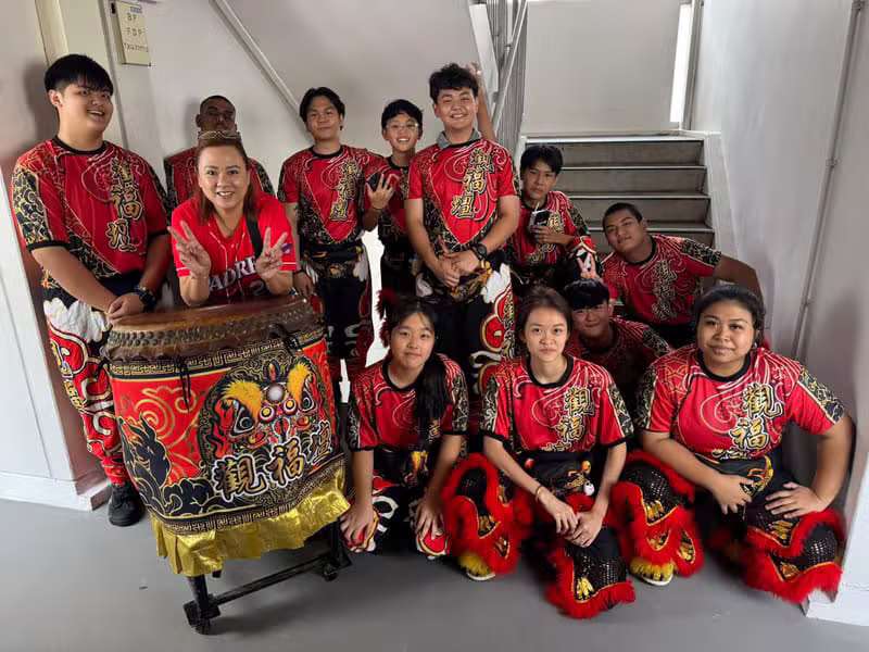 The full Hong Quan team posing together in uniform with the war drum and lion dance trousers