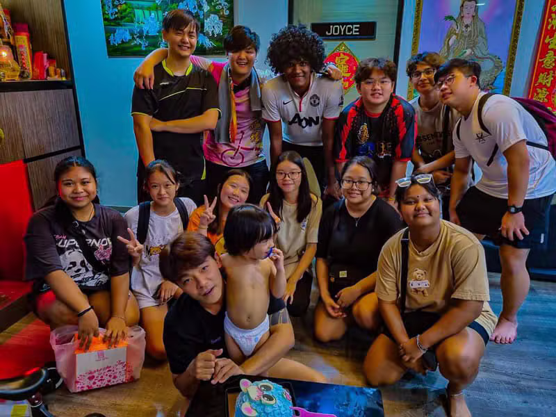 Hong Quan team and friends celebrating a birthday gathering indoors