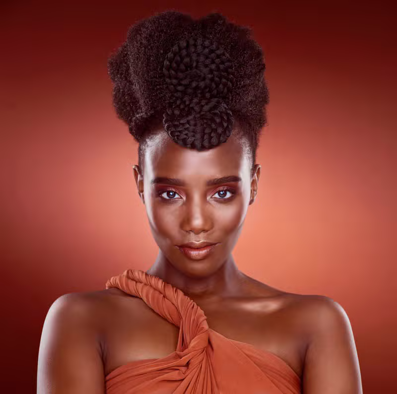 Black woman with freshly styled hair in a warm editorial salon setting