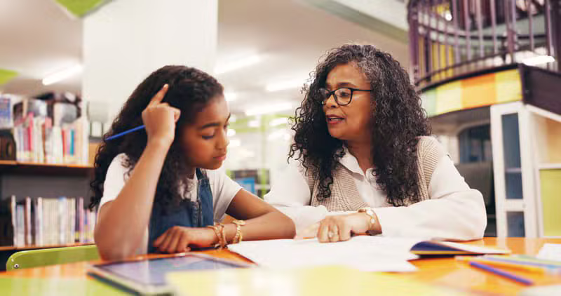Teacher helping children read in a classroom