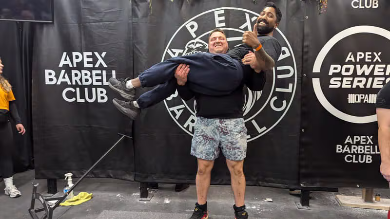 Vithusan J celebrating a heavy lift with a client at the Apex Barbell Club event