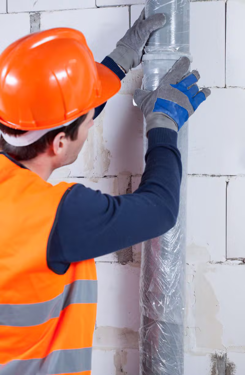 Professional contractor installing commercial pipe insulation