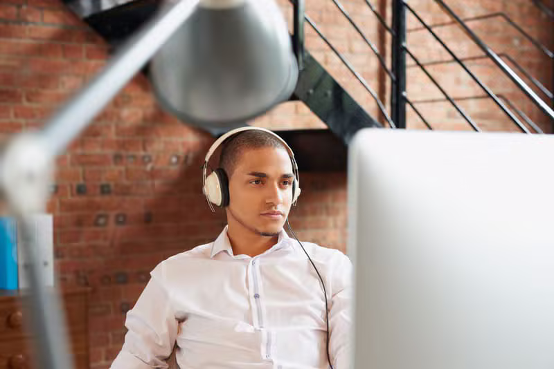 Hombre de negocios escuchando el podcast en su oficina