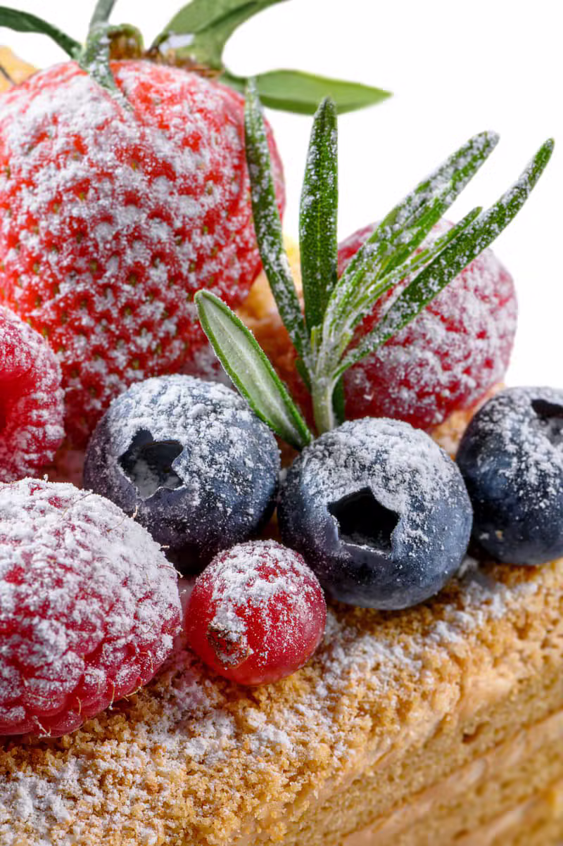 Colourful raw cake topped with fresh berries and fruits