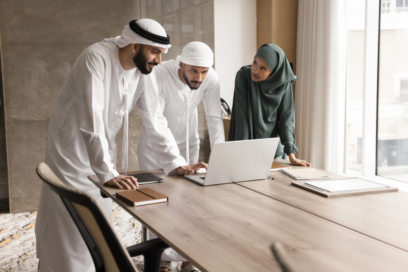 Open Quran on a wooden stand with students learning in the background