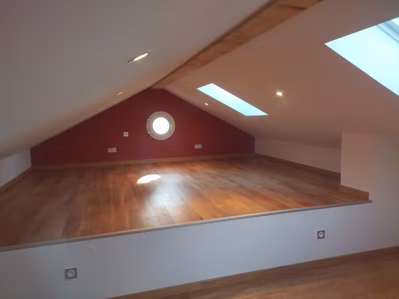 Combles aménagés avec parquet et grand mur peint