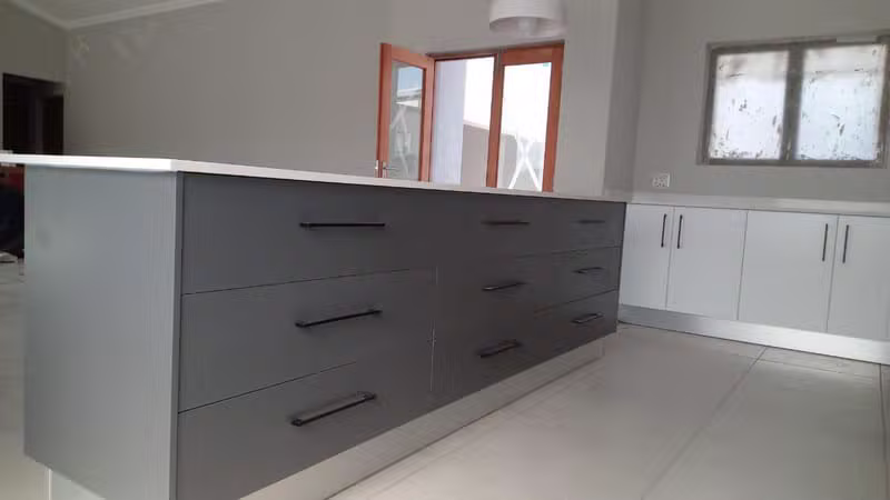 Grey kitchen island with large drawers by Dumakwizulu Group