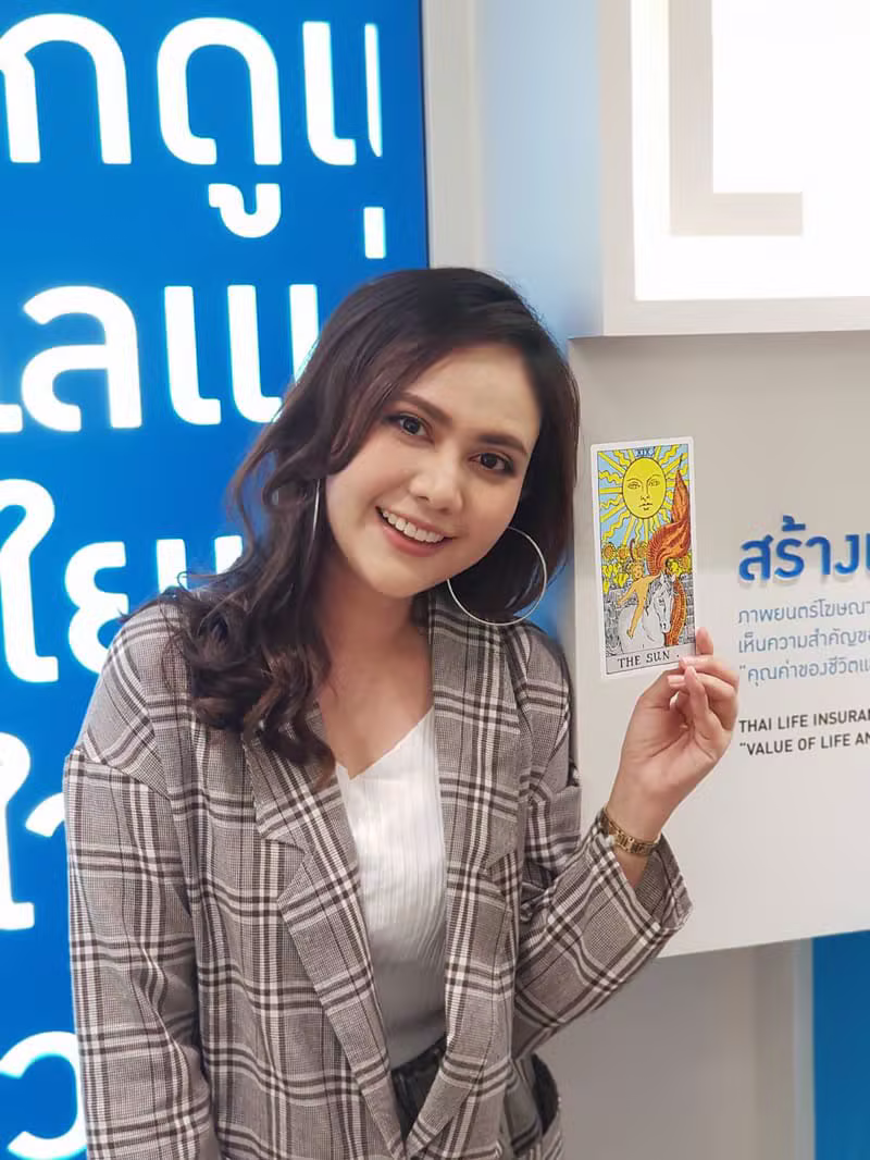 หมอควีนถือไพ่ทาโรต์เดอะซัน (The Sun) ในงานกิจกรรม Thai Life Insurance